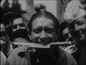 Un ouvrier pose avec un couteau entre les dents pour se moquer de la propagande anticommuniste, dans les années 1930