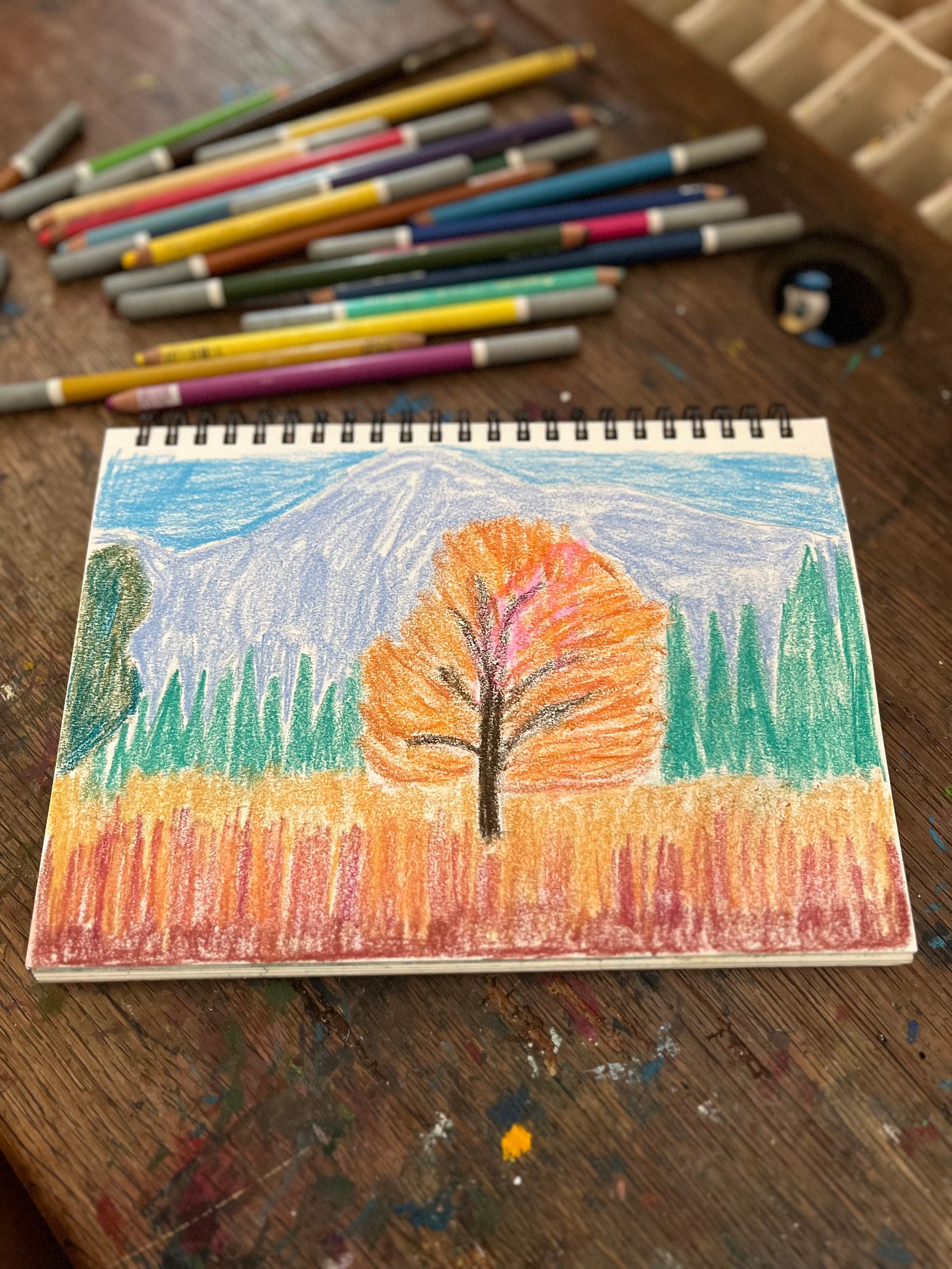 A dry pastel painting of a fall scene with a tree in front of mountains
