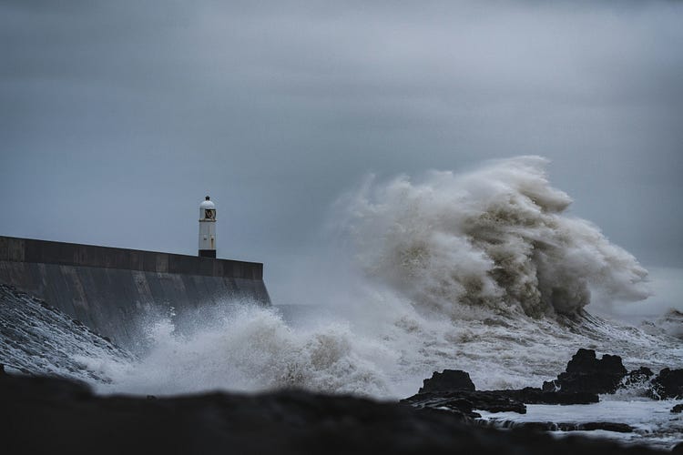 Lighthouse and waves at sea.