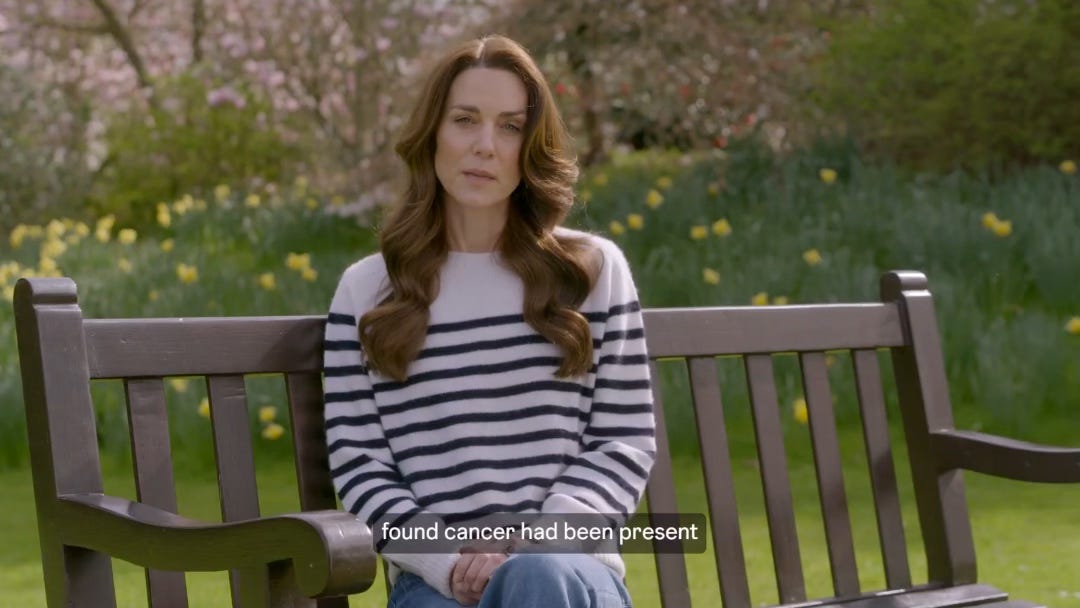 Princess of Wales, a still from the video. Sitting on a bench outside, she wears jeans and a horizontally striped sweater. 
