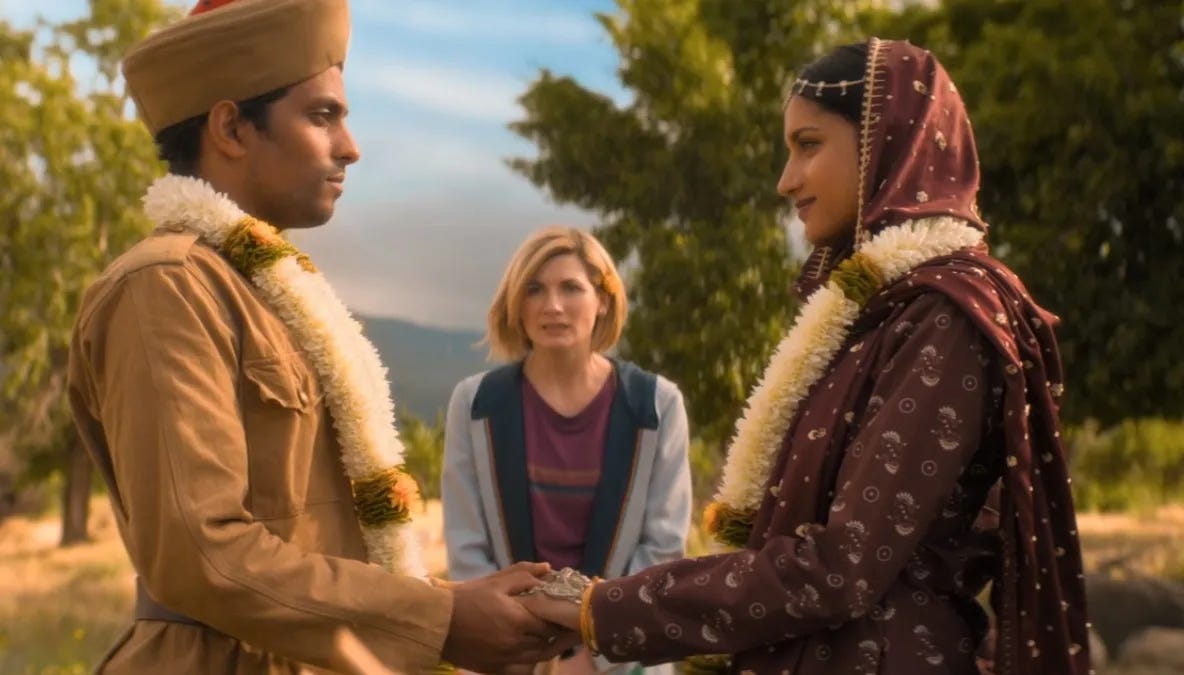 This image shows Prem (played by Shane Zaza, left) and the young Umbreen (played by Amita Suman, right) being married by the Thirteenth Doctor (played by Jodie Whittaker, center) in "Demons of the Punjab" (Doctor Who Series 11's sixth episode). This image shows Prem (played by Shane Zaza, left) and the young Umbreen (played by Amita Suman, right) being married by the Thirteenth Doctor (played by Jodie Whittaker, center) in "Demons of the Punjab" (Doctor Who Series 11's sixth episode).