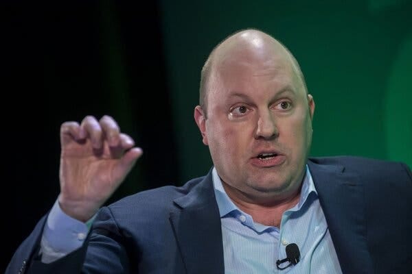 Marc Andreessen, wearing a blue shirt and suit, gestures while speaking. 