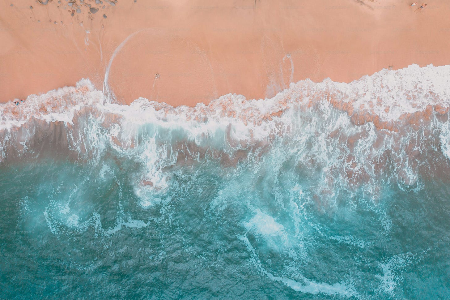 an aerial view of a beach with waves and sand