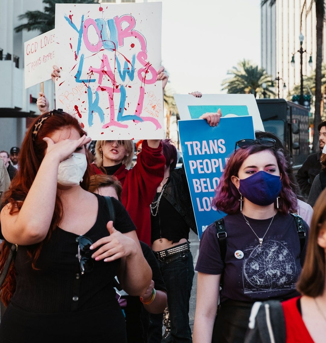 a group of people holding signs and wearing masks