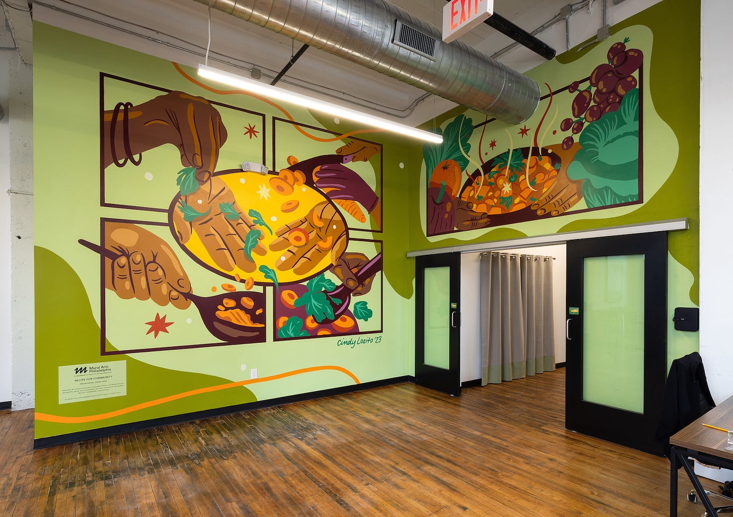 A mural featuring comics, hands, food preparation, and lush vegetables
