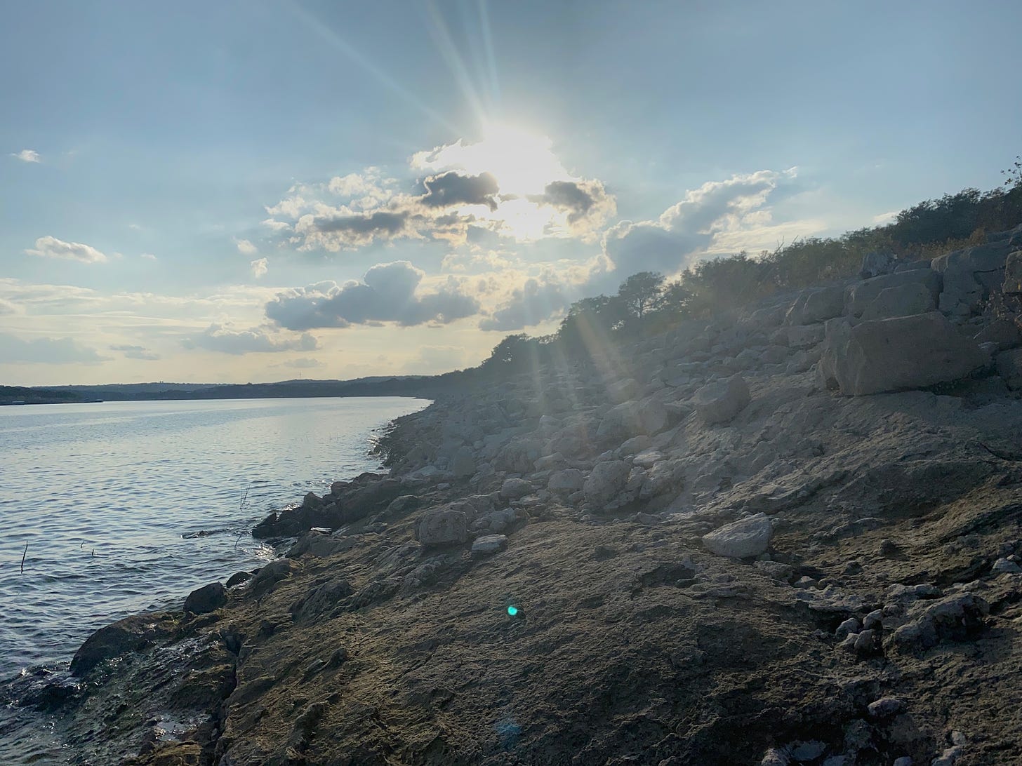 The Sun breaking through clouds on a shoreline