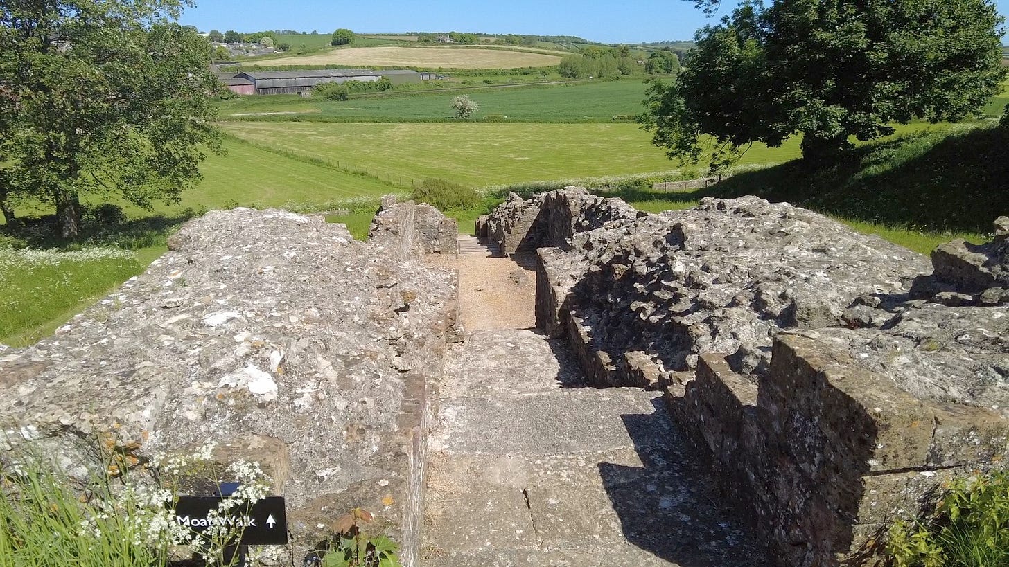The steep steps down to the Moat Walk. The green fields were once a lake that became silted up. It was here goods were delivered and had to be carried up the steps. Image: Roland’s Travels