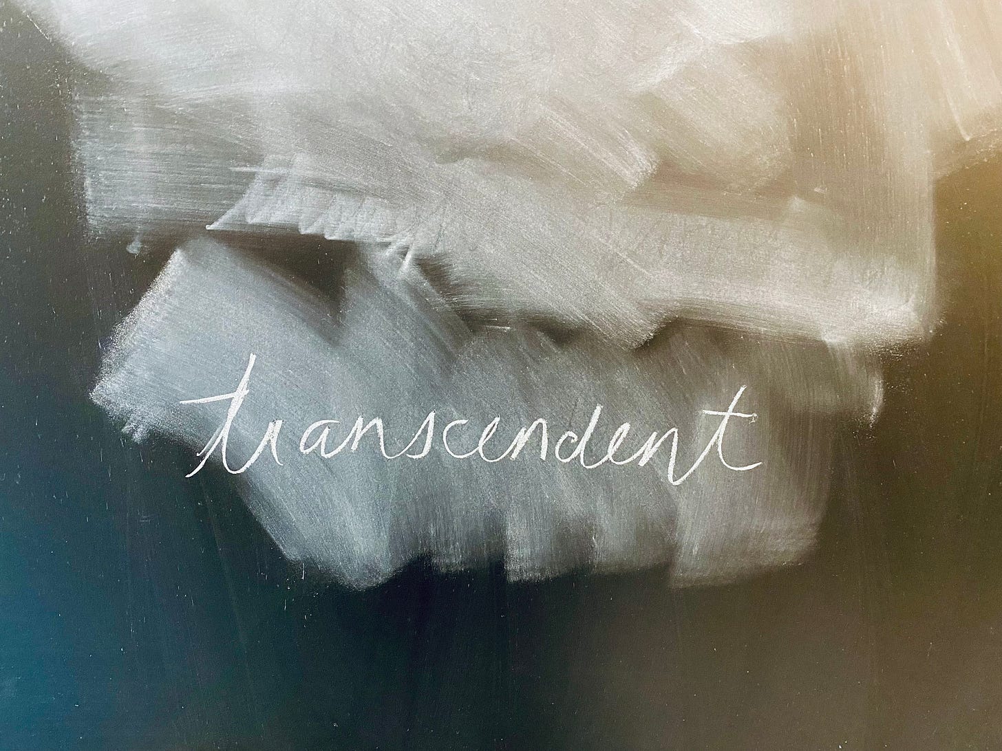 A chalkboard, erased except for the word ‘transcendent’ written in script