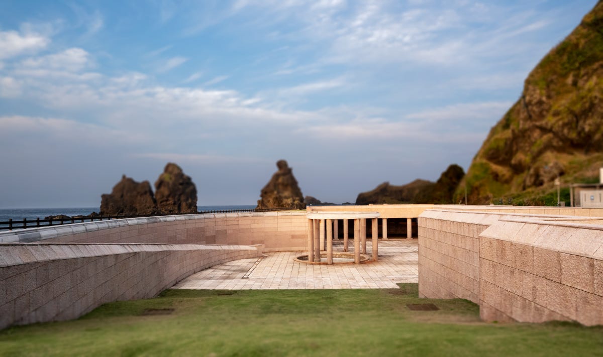 A limestone gazebo sits in a sunken courtyard at the center of the Green Island Human Rights Memorial Park