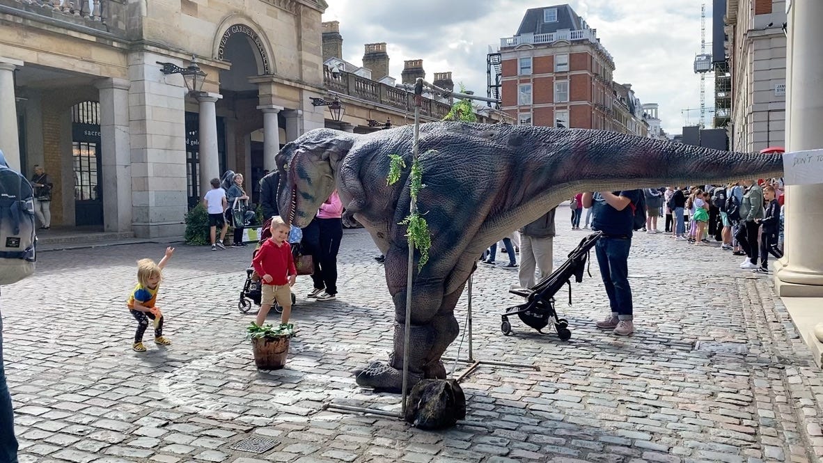 children in Covent Garden meet a dinosaur
