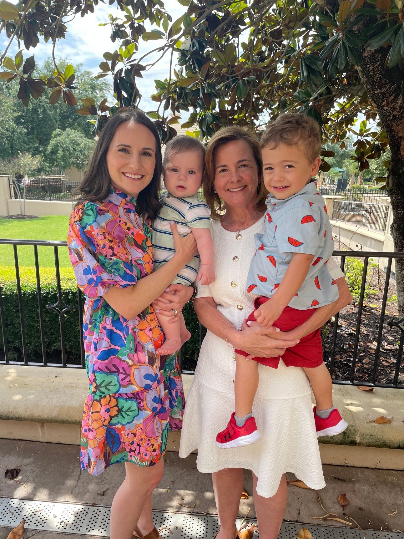 A mother holding her son, standing next to her mother holding her grandson A mother holding her son, standing next to her mother holding her grandson