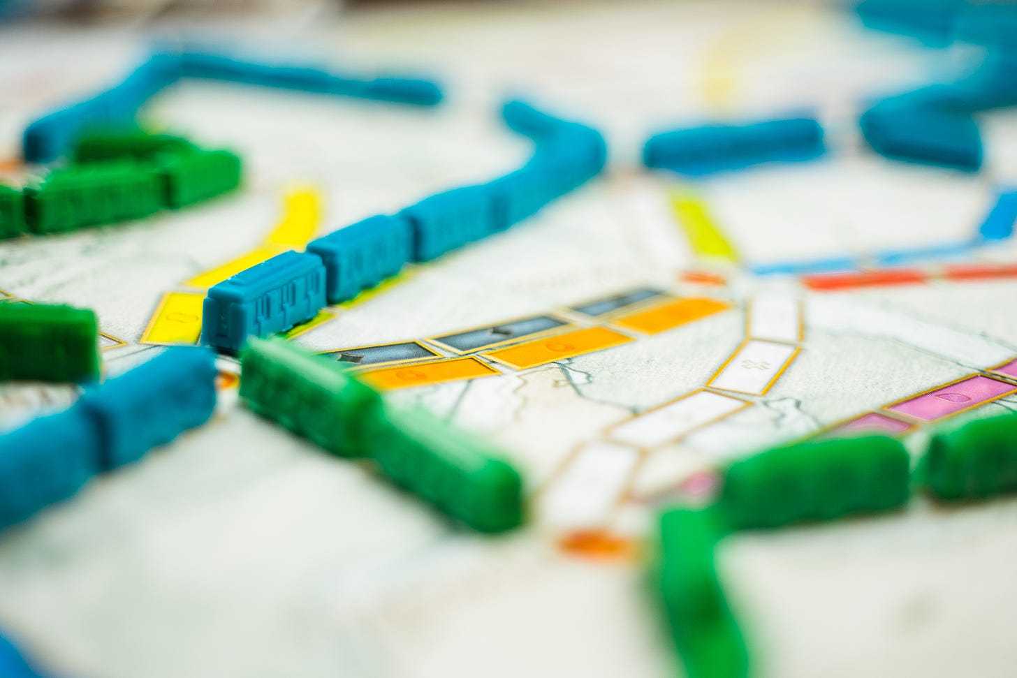 The board game Ticket to Ride, with blue and green trains crossing along the board.