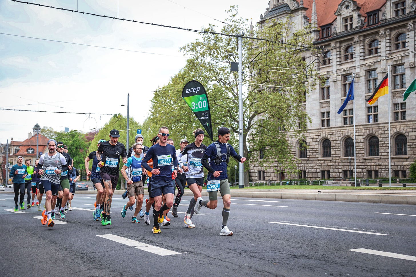 The author running in a group of runners with a pacer carrying a 3:00h flag