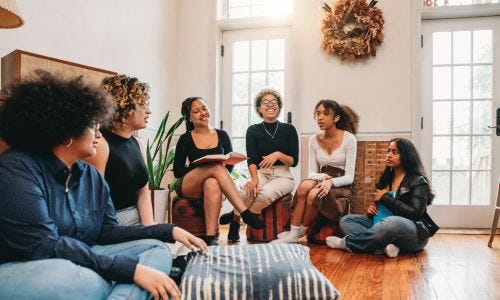 a book club meeting of various femme-presenting people of color with different hairstyles 