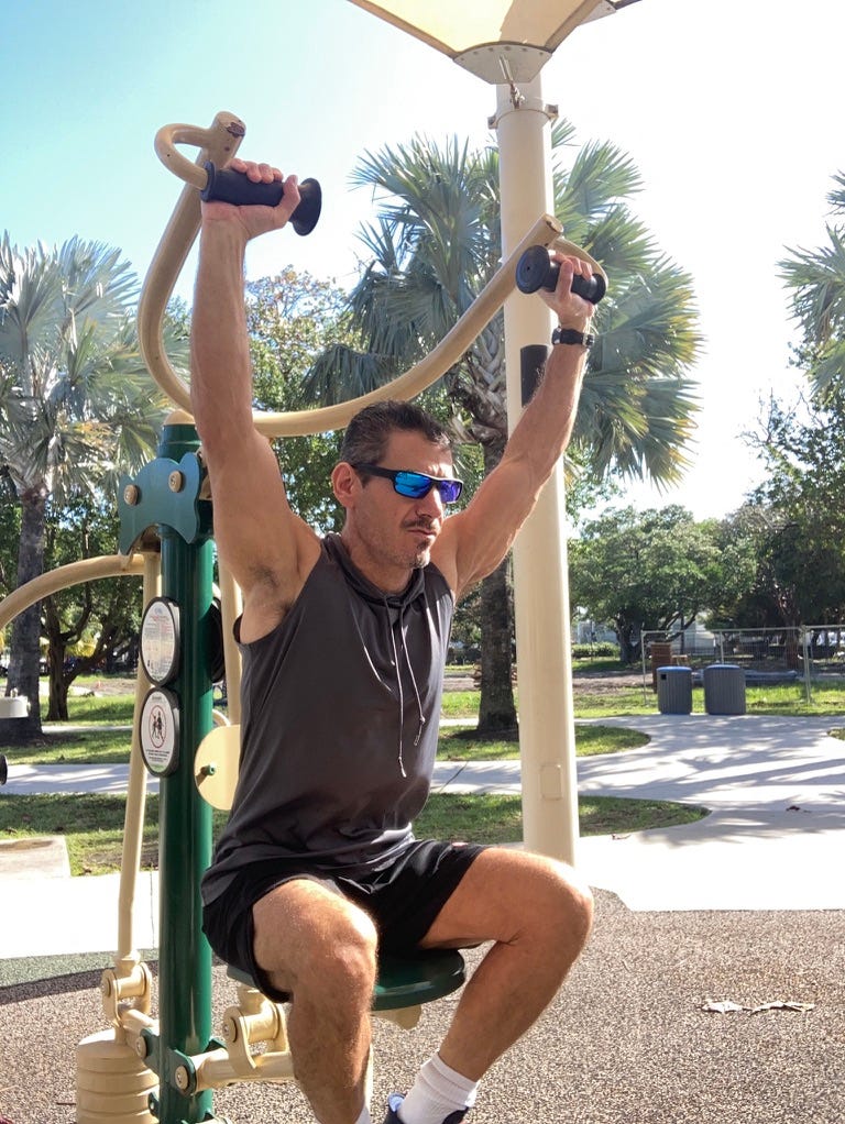 A person lifting weights on a playground

Description automatically generated
