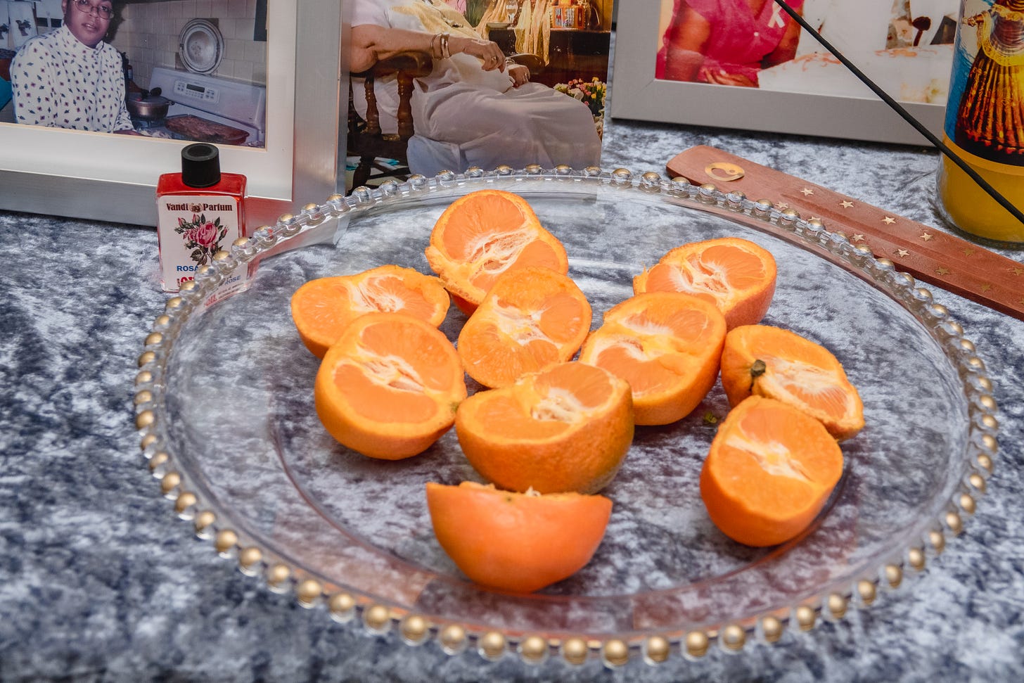 Sliced oranges, rose oil, incence on a table with a blue table cloth