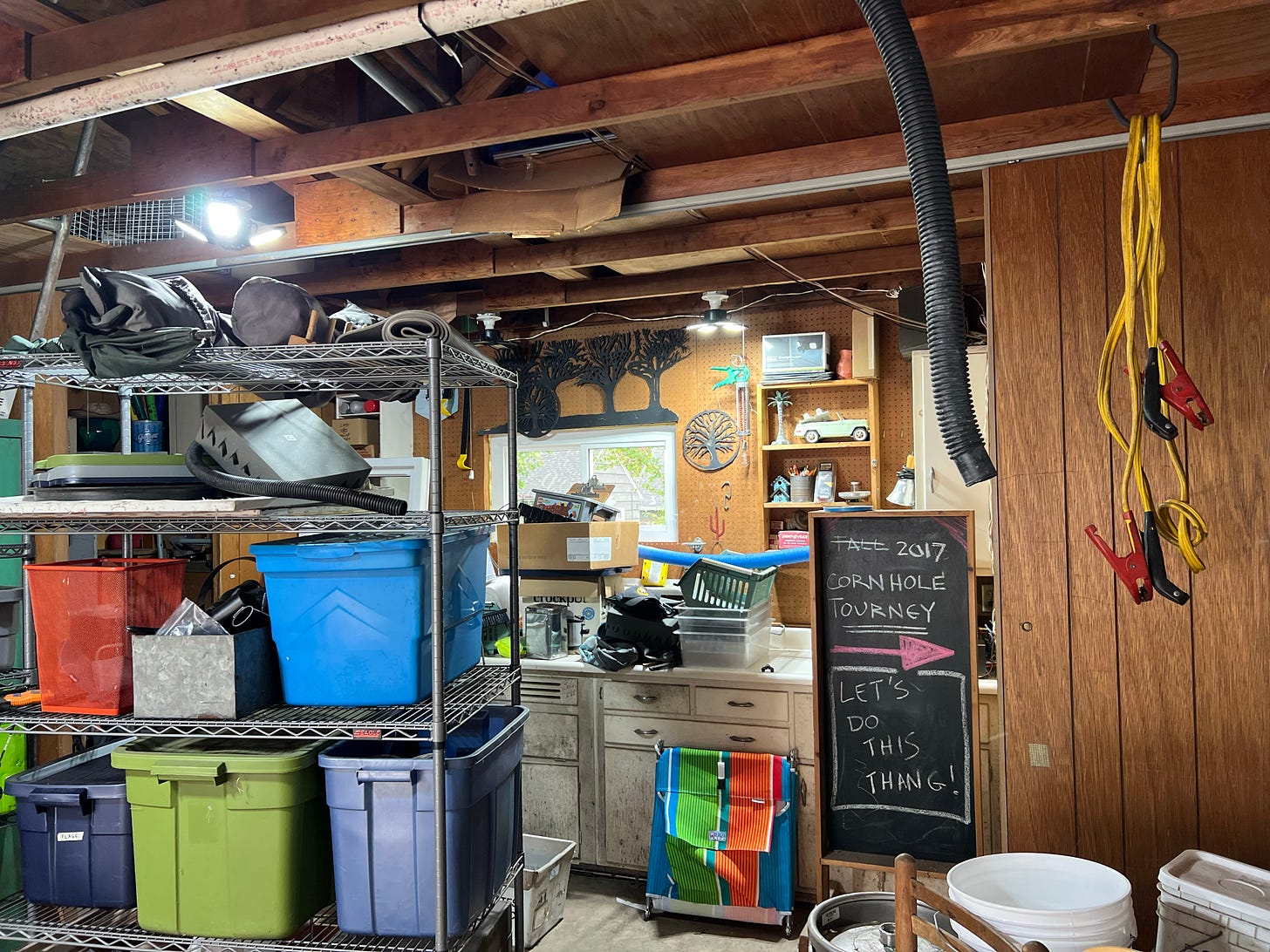 Image of paneled garage filled with bins, shelves, jumper cables and all manner of garage junk
