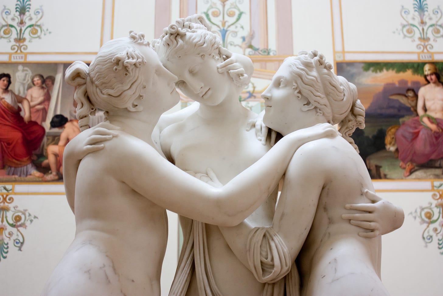 this is a photo of "The Three Graces" by Antonio Canova. It's a sculpture that features three women touching each other. It's not meant to be sensual but I'm using it to be sensual anyway because I want to 