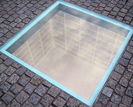 Bebelplatz Book-burning Memorial at Humboldt University in Berlin, Germany. The memorial is a a glass window in the ground through which people can peer into an underground room with empty shelves for the 20,000 books and papers that were destroyed.