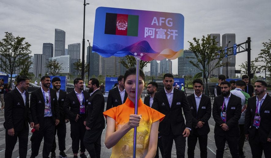 A volunteer holds up country&#x27;s sign for Afghan men&#x27;s only team during a welcoming ceremony at the 19th Asian Games in Hangzhou, China, Wednesday, Sept. 20, 2023. In the first Asian Games since the Taliban regained control of Afghanistan, two teams of athletes are arriving in the Chinese city of Hangzhou, looking very different. One, sent from Afghanistan where women are now banned by the Taliban from participating in sports, consists of about 130 all-male athletes, a Taliban-appointed spokesman for the Afghanistan’s Olympic Committee told The Associated Press. Another, competing under the black, red and green flag of the elected government the Taliban toppled in 2021, is drawn from the diaspora of Afghan athletes around the world, and includes 17 women. (AP Photo/Louise Delmotte, File)