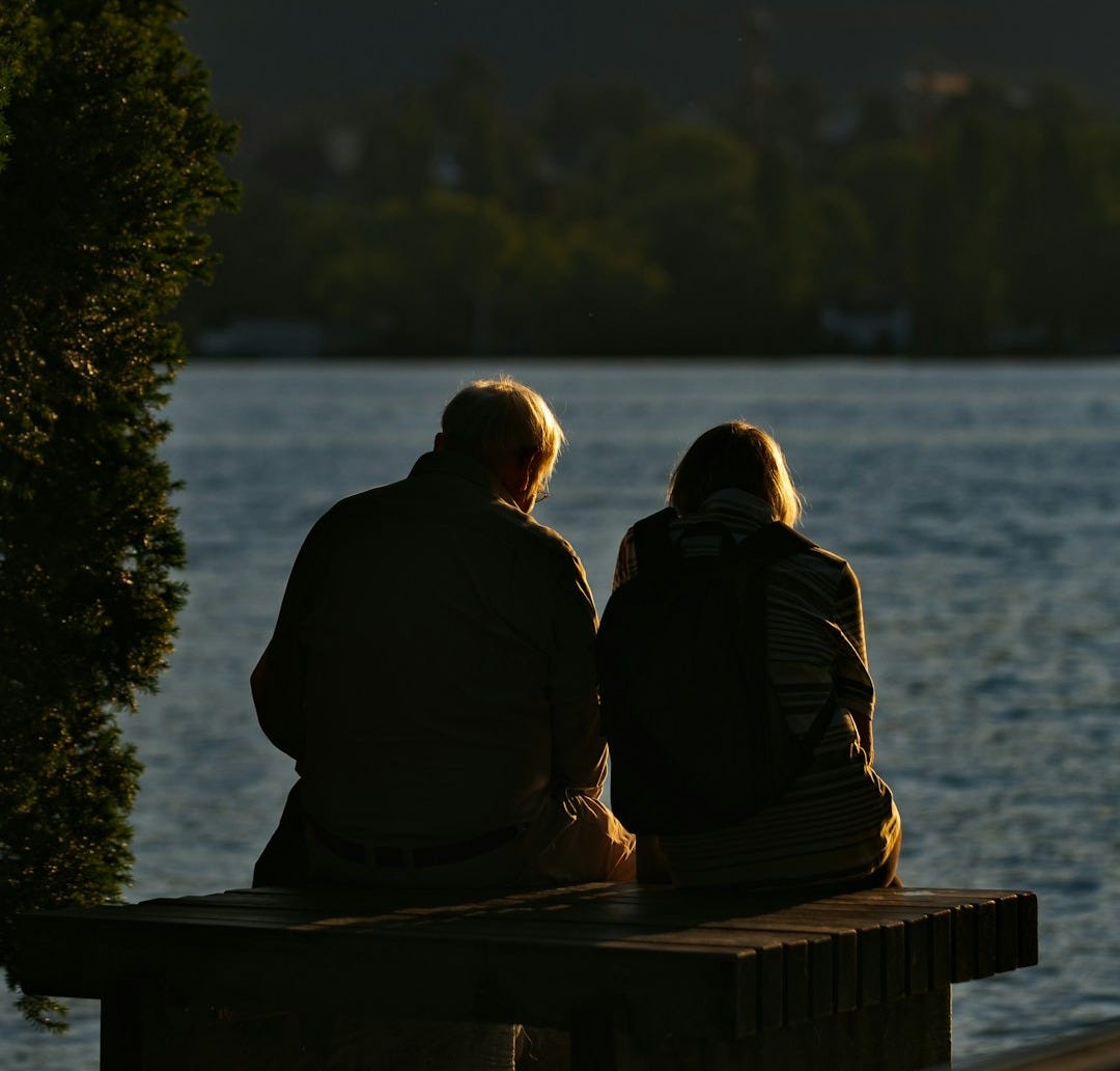 man and woman standing near body of water during daytime