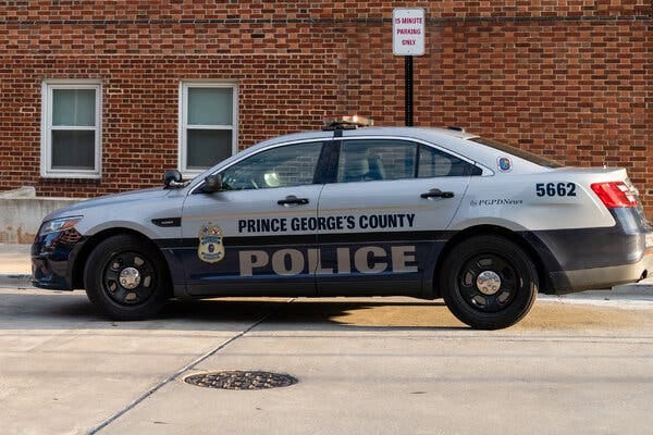 A patrol vehicle of the Prince George’s County Police Department, is parked by a building with a brick facade.