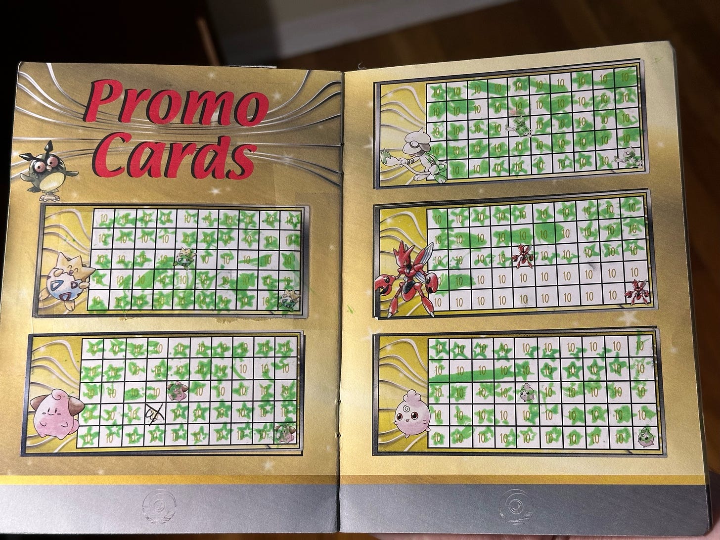 Inside Greg's badge book, showing progress towards obtaining promo cards Togepi, Cleffa, Smeargle, Scizor, and Igglybuff