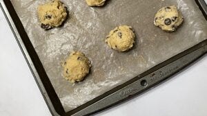 Raw chocolate chip cookies on a pan.