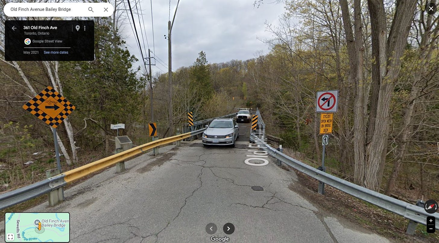 A Street View screengrab of two cars driving over the Old Finch Bailey Bridge. It is May 2023 and the Rouge Valley has not become very green yet. 