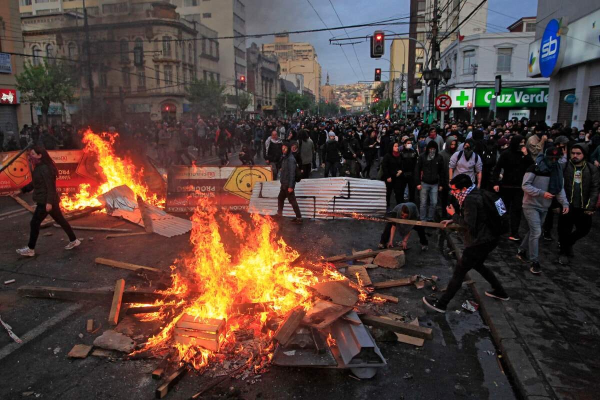Protesters light bonfires in Vaparaiso, Chile. Chilean President Sebastian Pinera announced Saturday the suspension of the increase in the price of metro tickets, which had triggered violent protests.