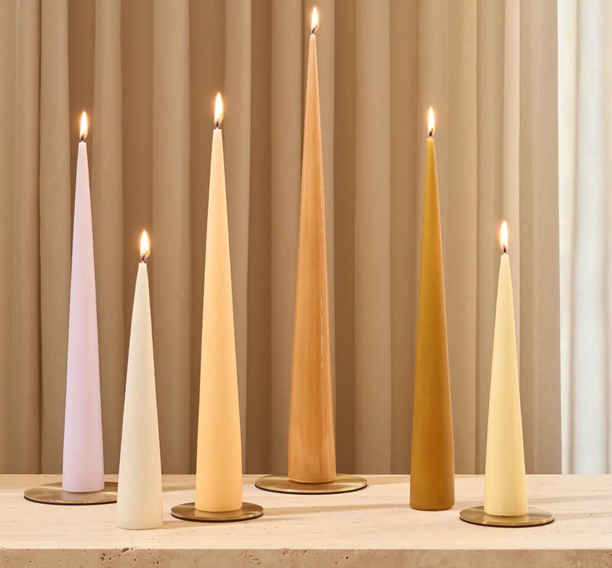 collection of tapered candles in varying heights in a neutral colour palette