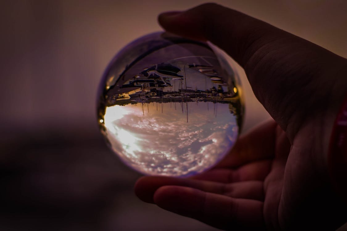 Free Selective Focus Photography of Person Holding Glass Ball Stock Photo