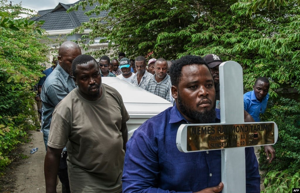 Mourners proceed bearing a cross and a coffin with the body of Tanzanian student, Nemes Tarimo, whose body arrived at his homeplace in Dar es Salaam, Tanzania, after he was killed fighting for Russia in Ukraine after being recruited in jail.