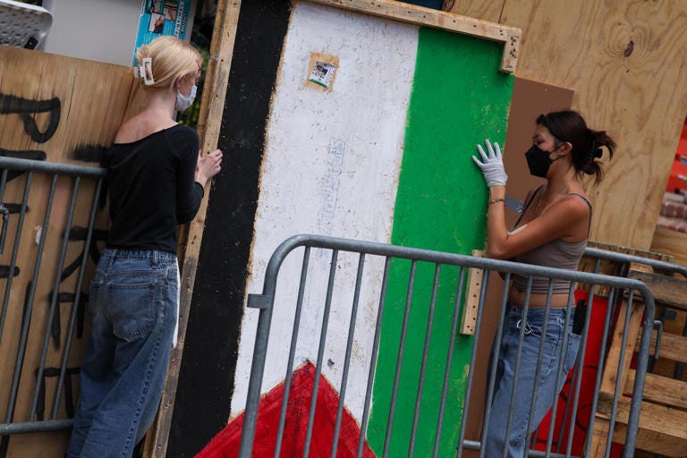 Pro-Palestinian encampment participants reinforce the camp barriers at UCLA on May 1. ((Brian van der Brug / Los Angeles Times))