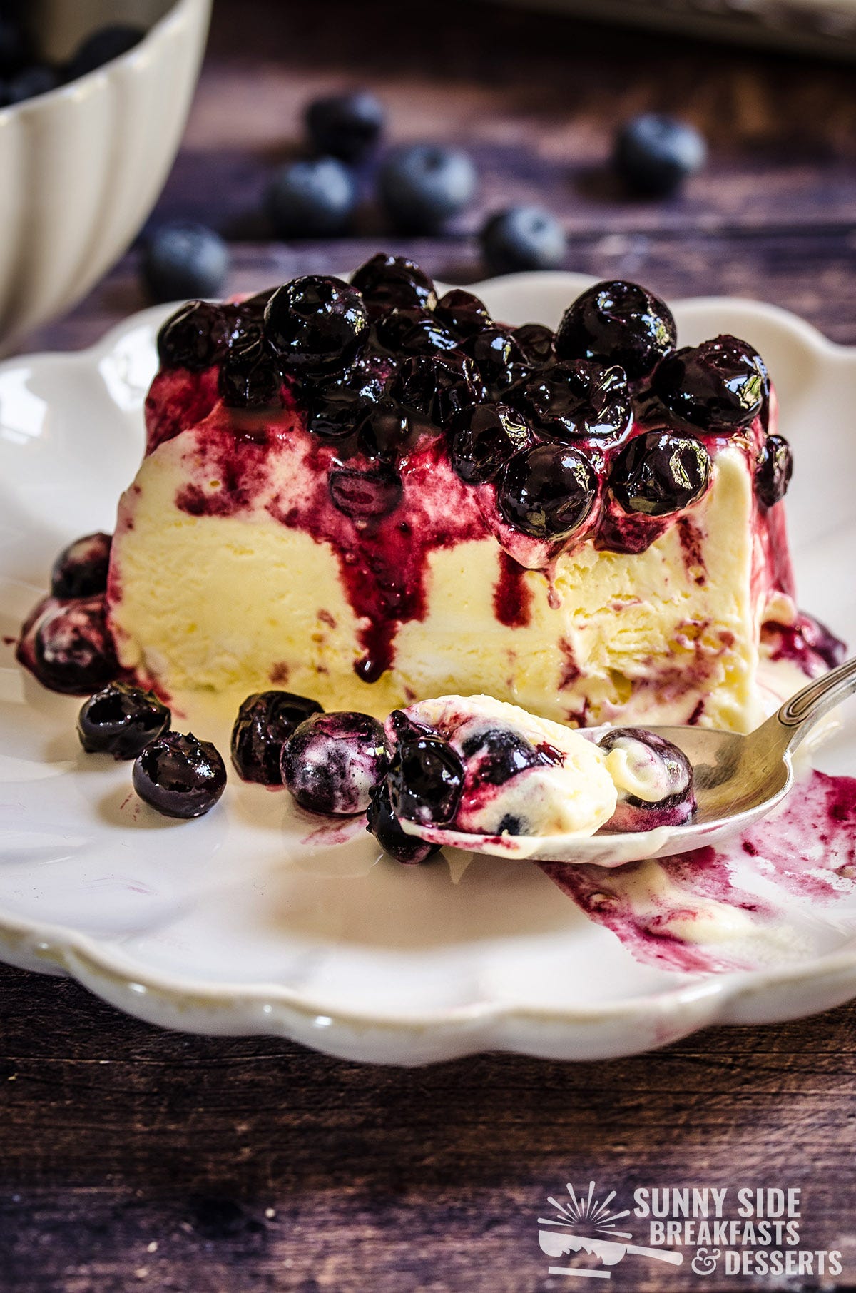 A slice of lemon blueberry semifreddo with a spoon.