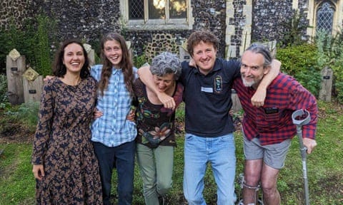 The five defendants smiling in a group pose in a church yard