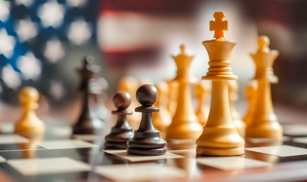 Out of focus American Flag in the background with a chessboard and white and black chess pieces