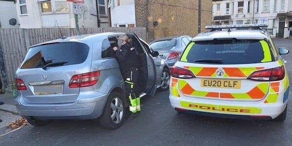 Marked police car and officer seizing a vehicle