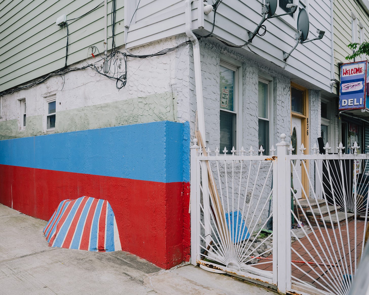 Corner-Of-Building-And-Rock-Painted-With-Blue-And-Red-Stripes