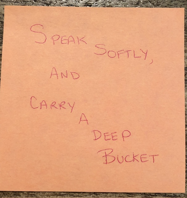 An orange sticky note, with the words, "Speak Softly, and Carry a Deep Bucket"