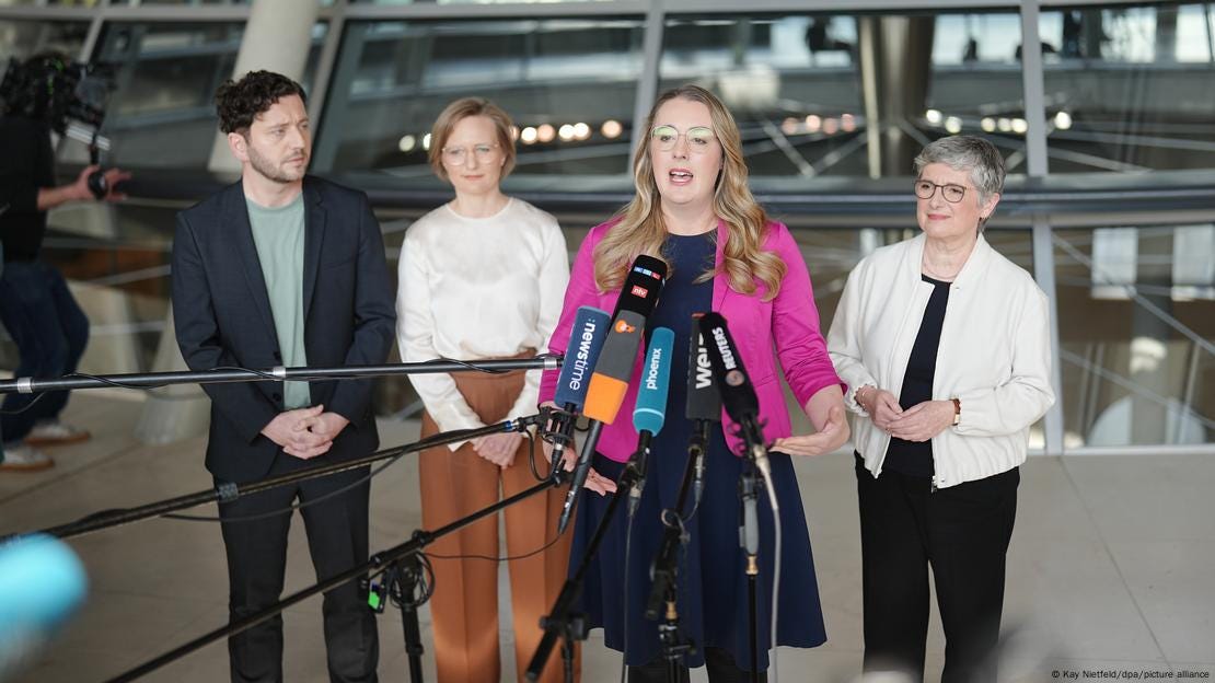Die Partei- und Fraktionsspitze der Grünen gibt auf der Plenarebene des Bundestags eine Pressekonferenz: Felix Banaszak, Franziska Brantner, Katharina Dröge Britta Haßelmann (v.l.) sprechen abwechselnd in Mikrofone, die ihnen an langen Stangen befestigt entgegengestreckt werden.  