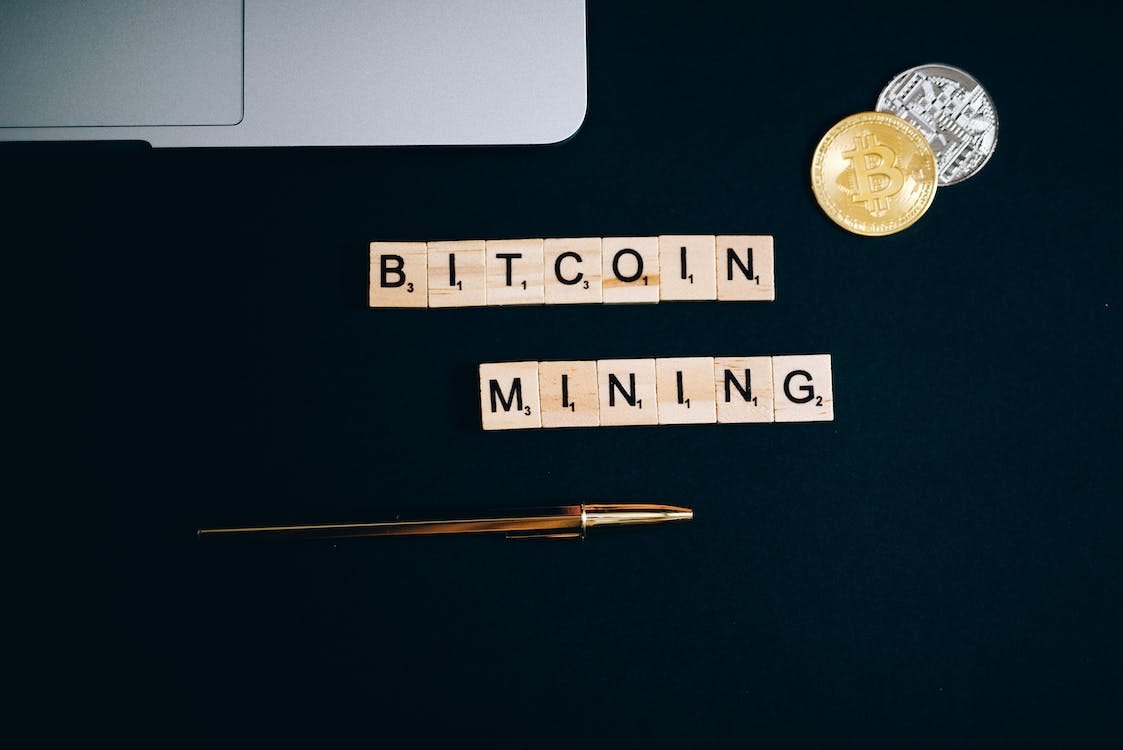 Free A Bitcoin and Pen on a Black Surface Stock Photo