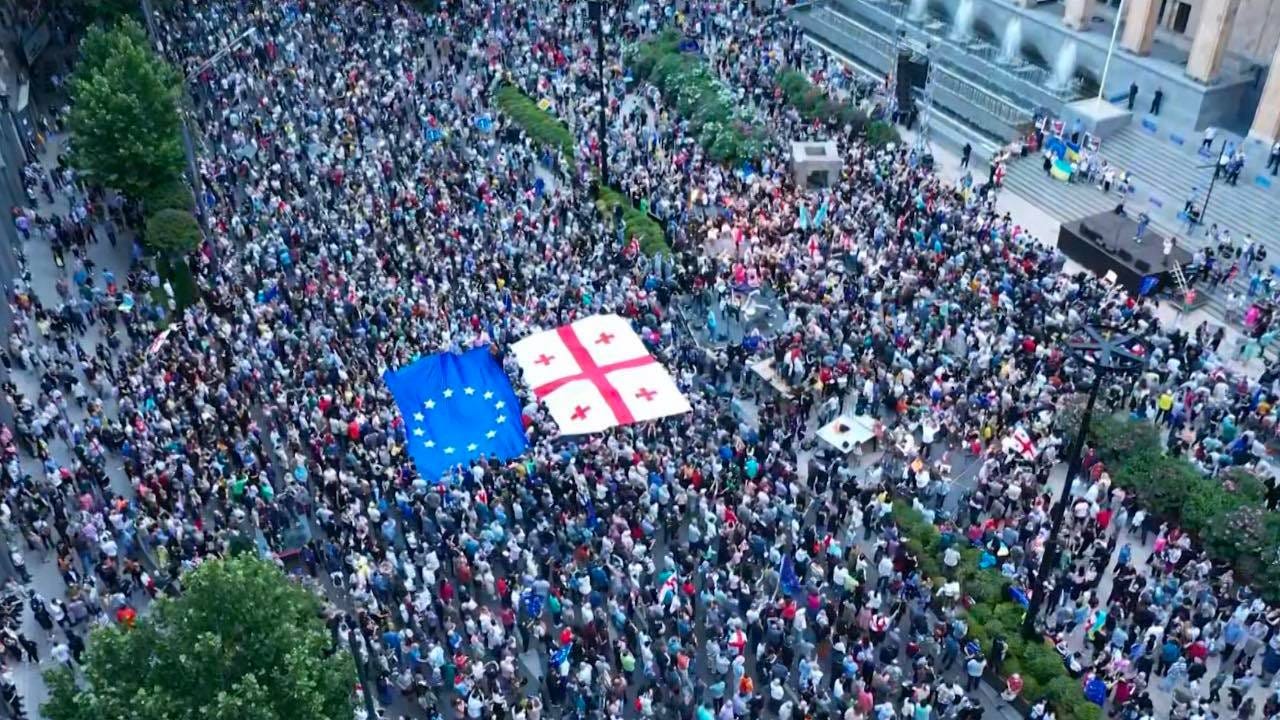 A crowd gathered outside Georgian Parliament, holding up the Georgian and EU flags.