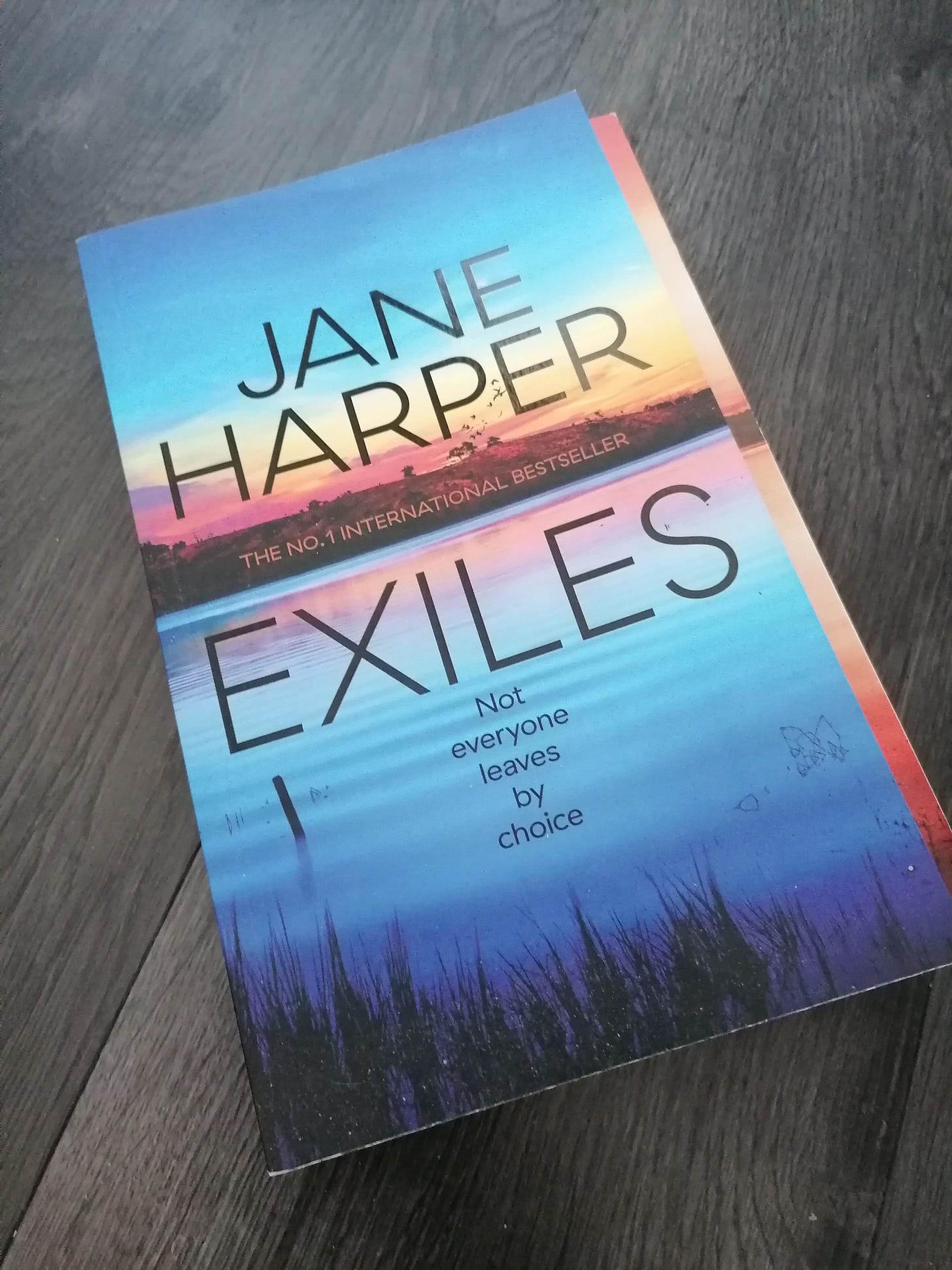 Cover shot of proof copy of Jane Harper's Exiles on wooden floor 