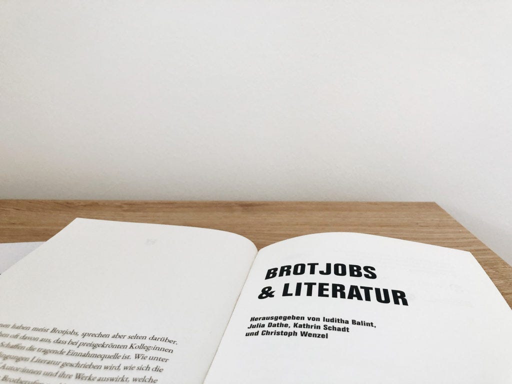 Buch Brotjob & Literatur und Notizbuch liegen auf einem Schreibtisch