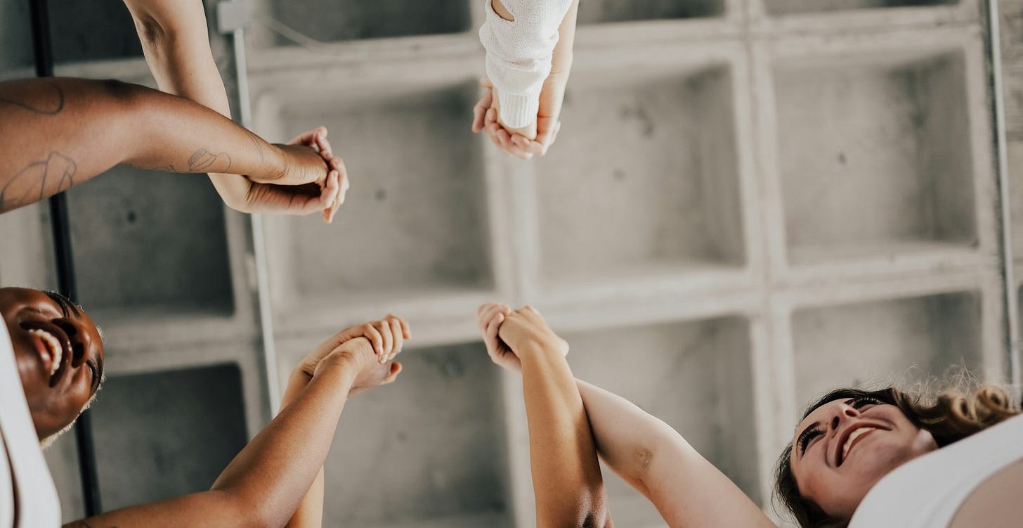 a group of people standing in a circle holding hands