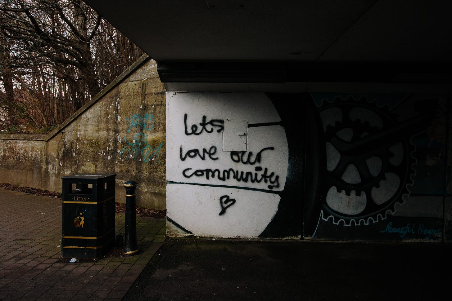 Imagem: Uma pichação escrita "Lets love our comunity" <3