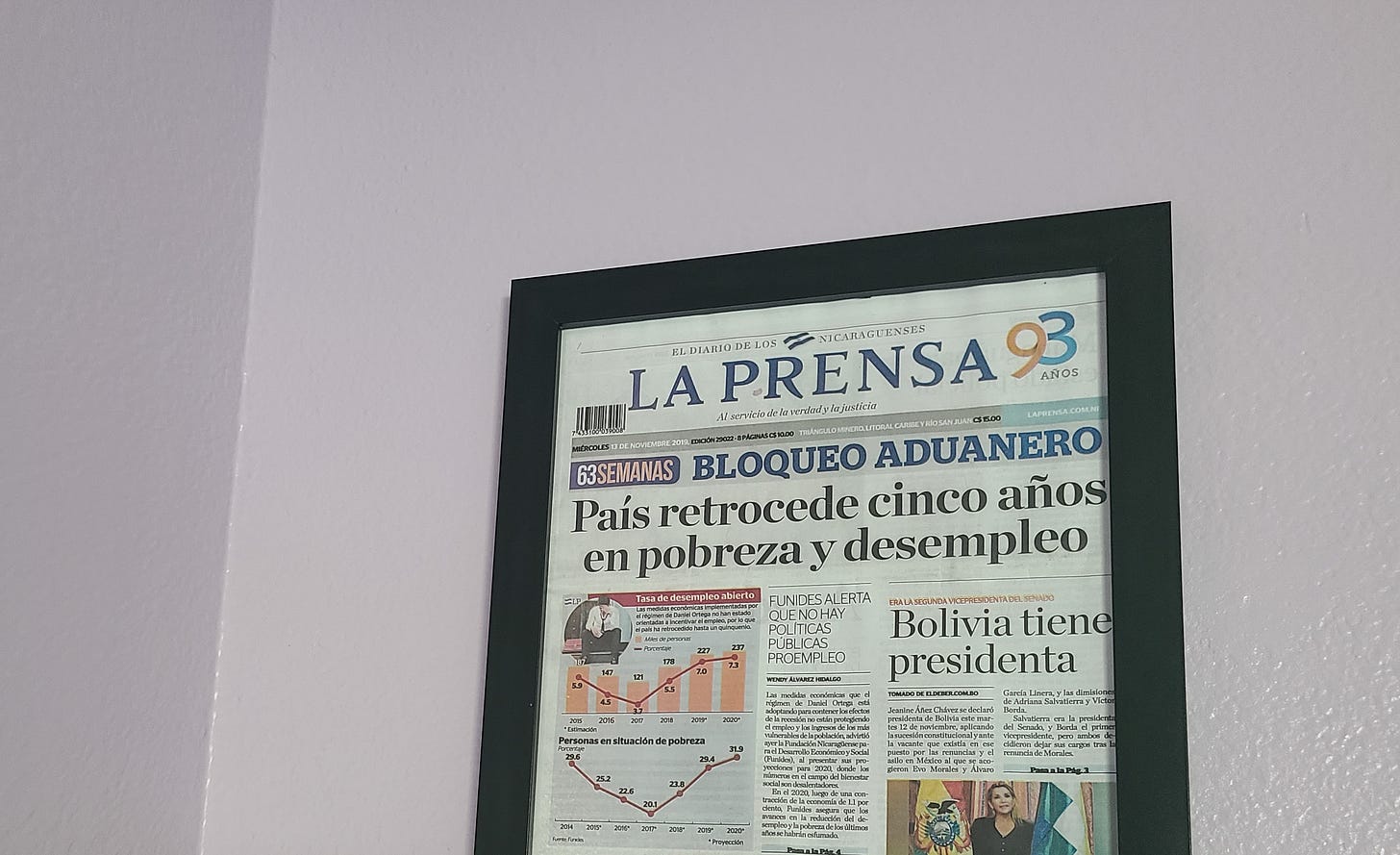 A framed newspaper hung on a purple wall