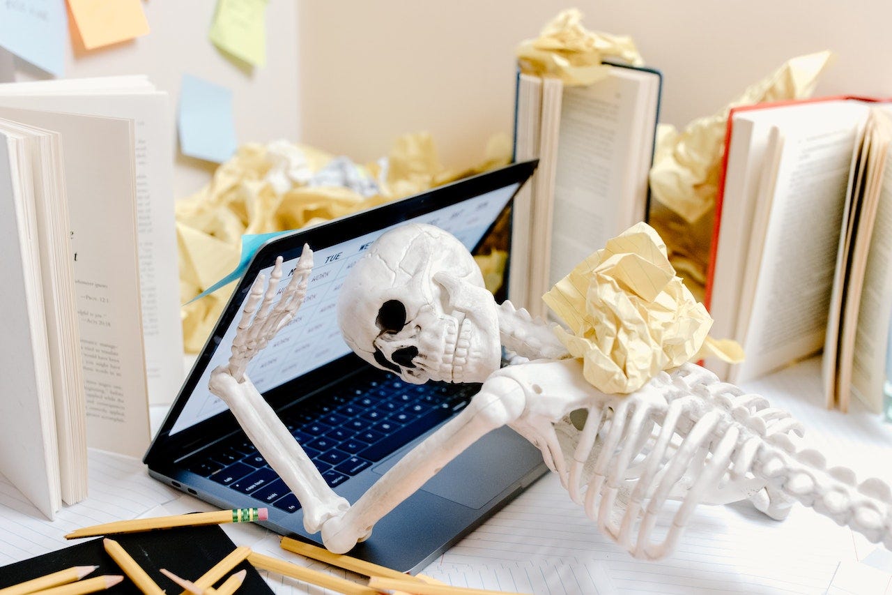 A toy skeleton lying face down on a laptop.