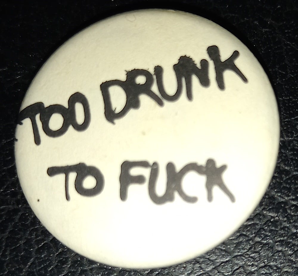A white badge with black writing. It says "Too drunk to fuck".
